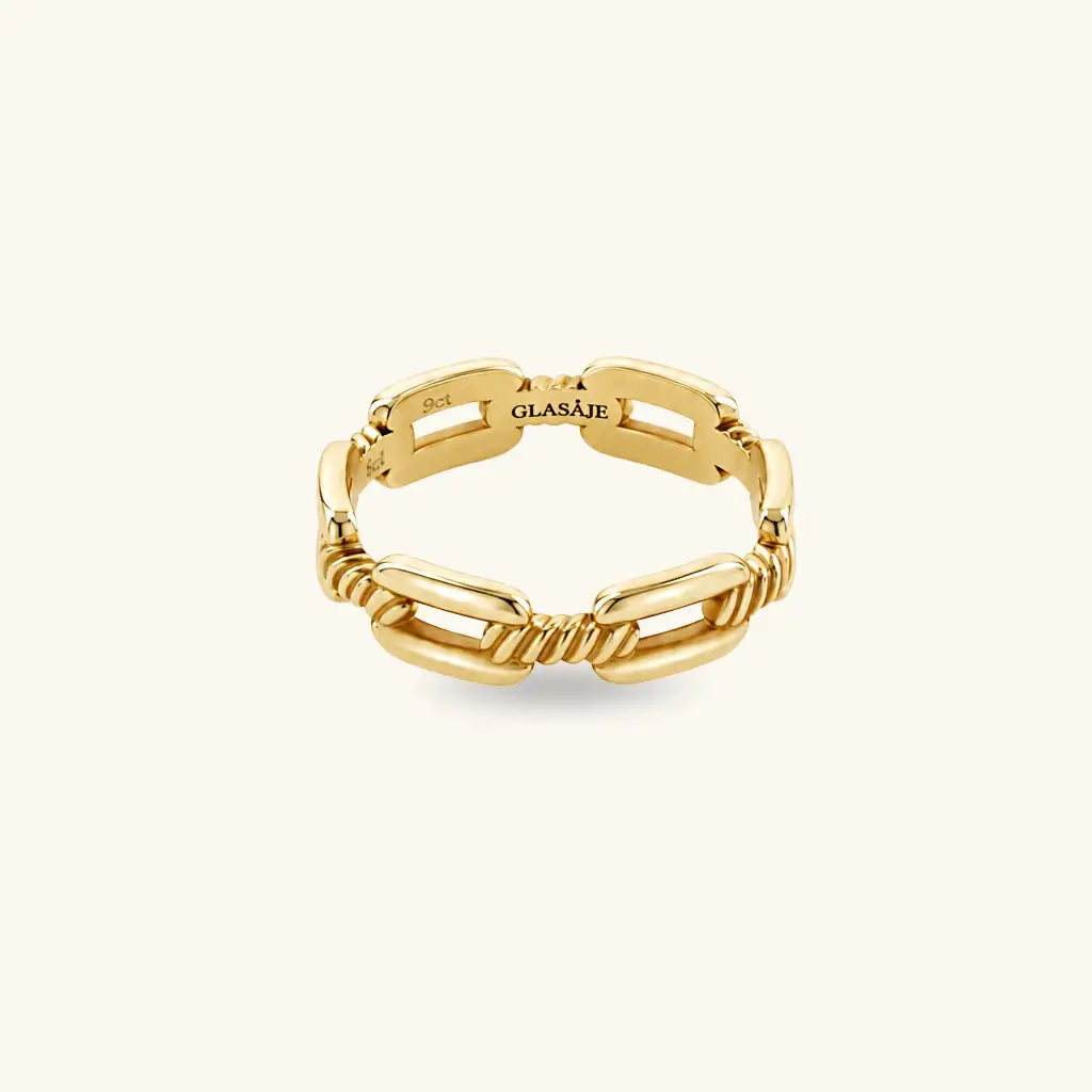 A gold chain-link ring with twisted rope details, shown on a clean off-white background. The brand name 'GLASAJE' is engraved on the inside of one of the links.