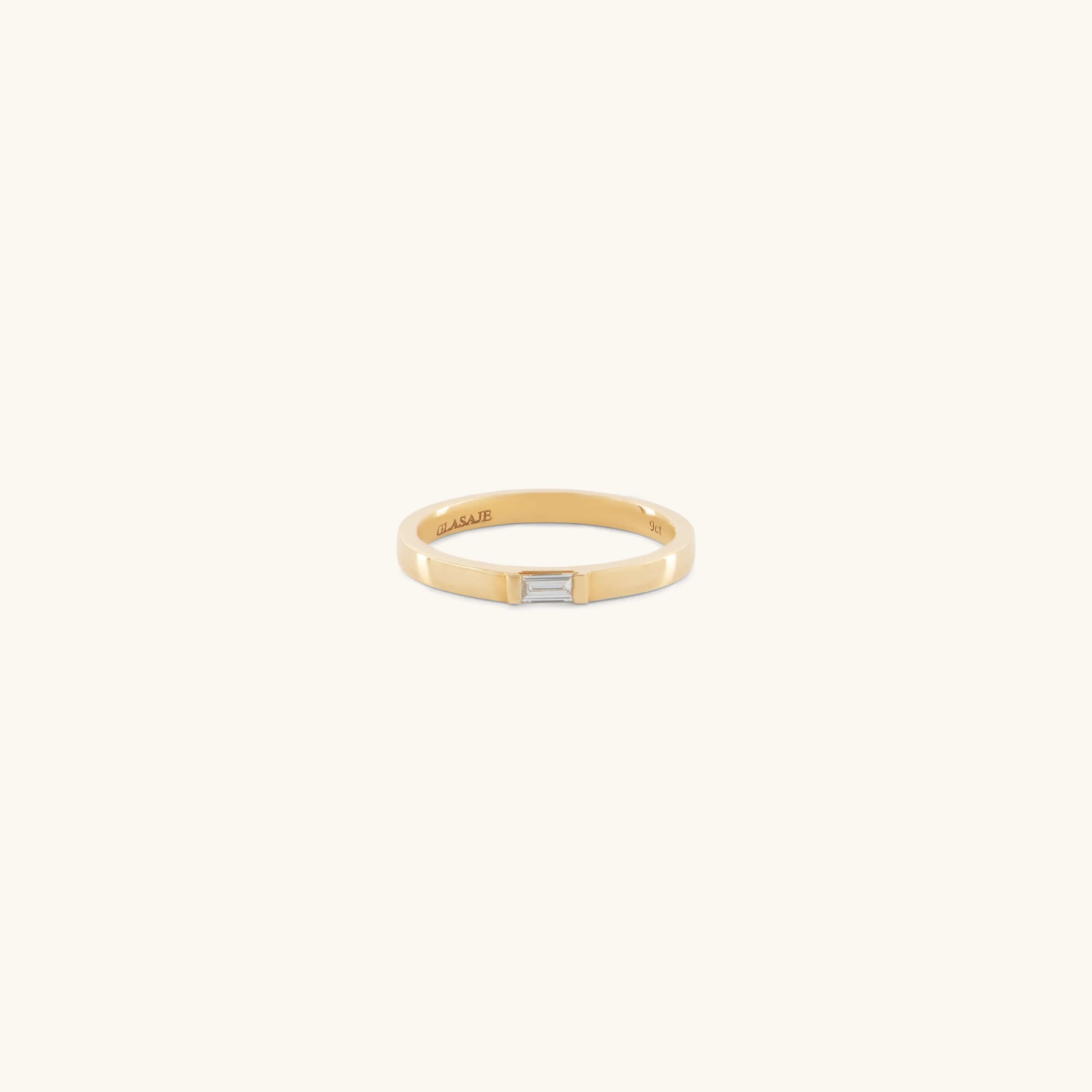 The Glasâje Siglo Ring features a simple gold band with a small rectangular ethical diamond set at the center, shown against an off-white background.