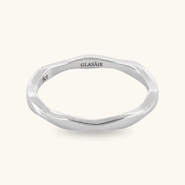 A polished silver ring with an organic, wavy, fluid outline shape, featuring the brand name 'GLASAJE' and '925' sterling silver mark engraved on the inside, set against a solid off-white background.