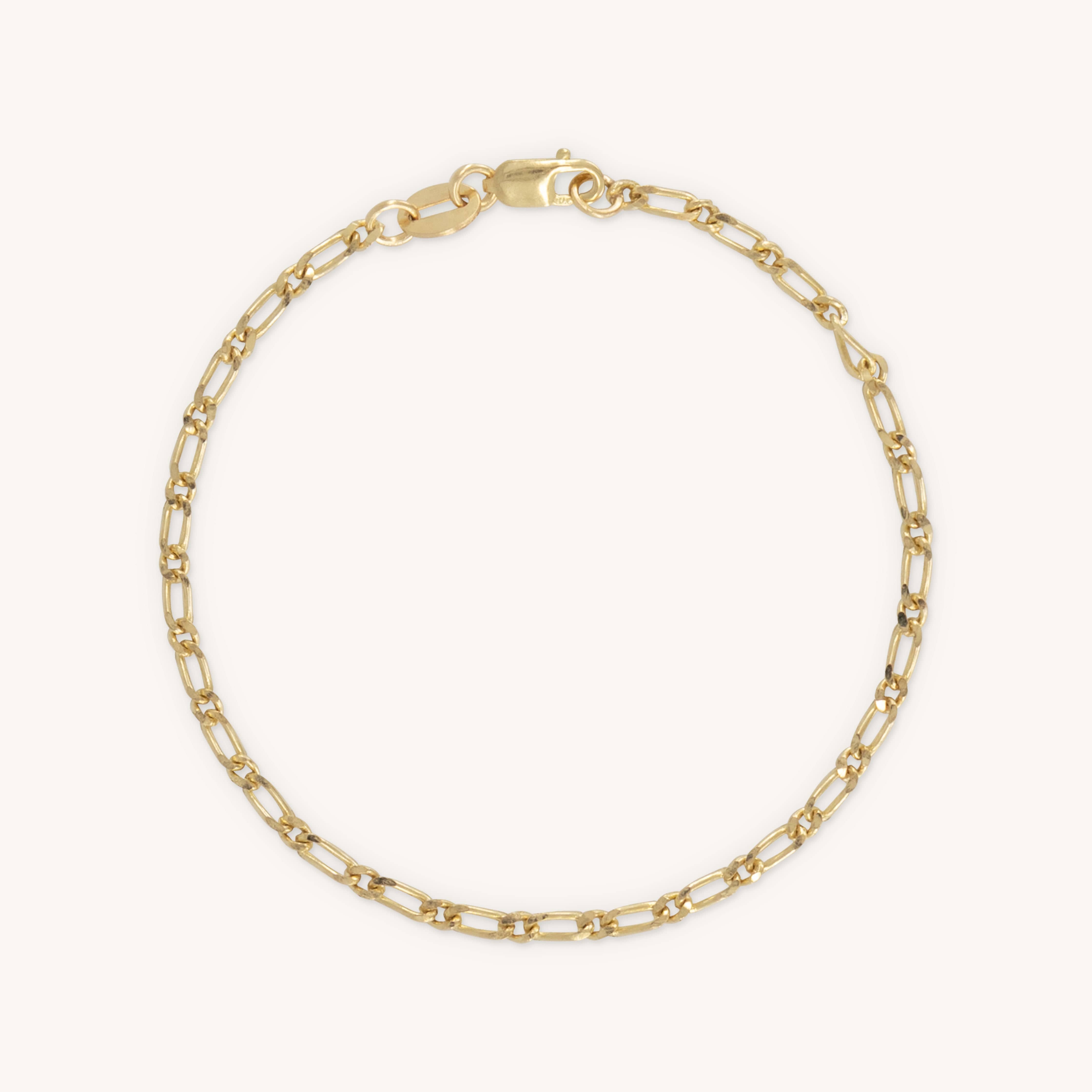 Gold chain bracelet with oval links and a lobster clasp, displayed on a plain white background. The bracelet's simplicity conveys elegance and sophistication.