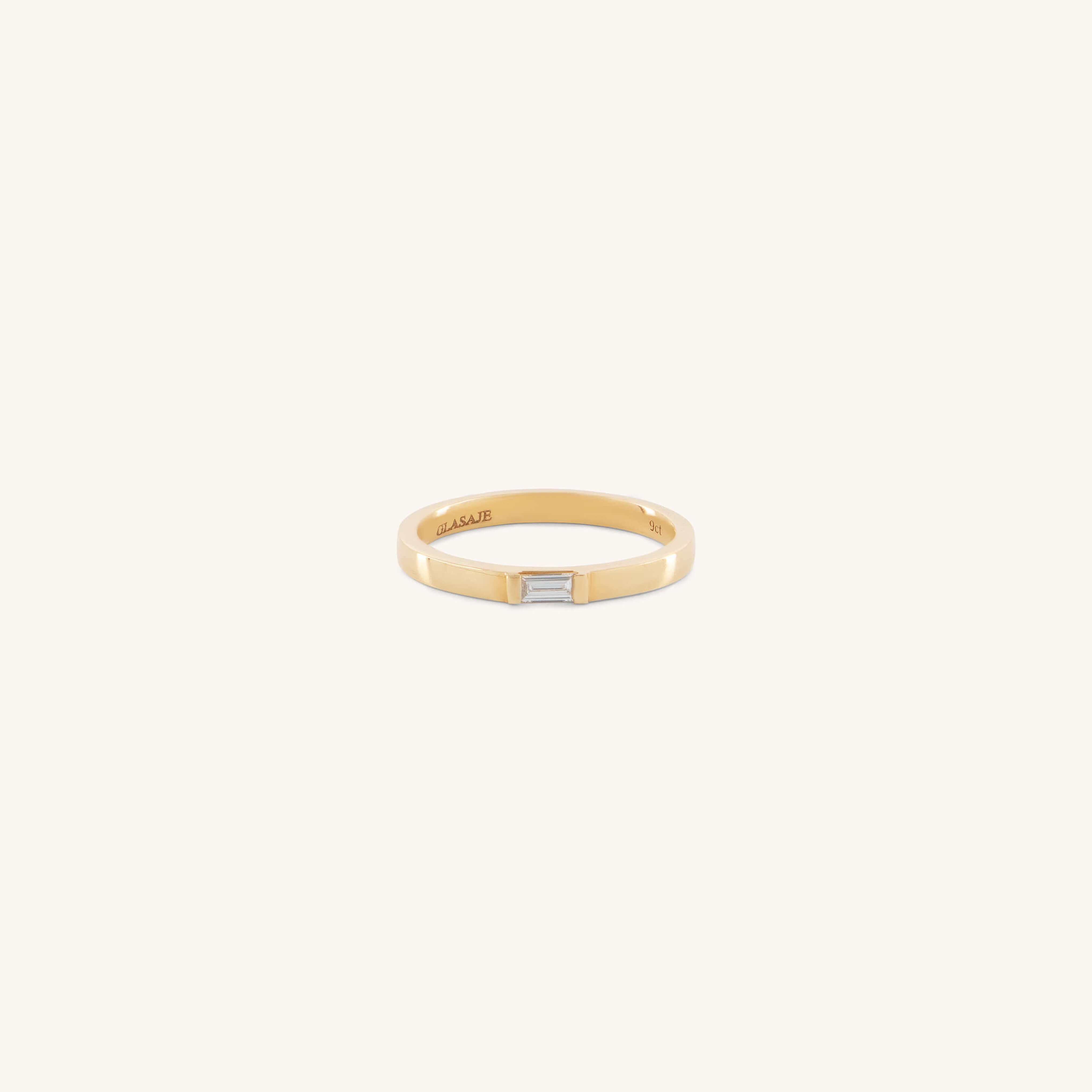 The Glasâje Siglo Ring features a simple gold band with a small rectangular ethical diamond set at the center, shown against an off-white background.